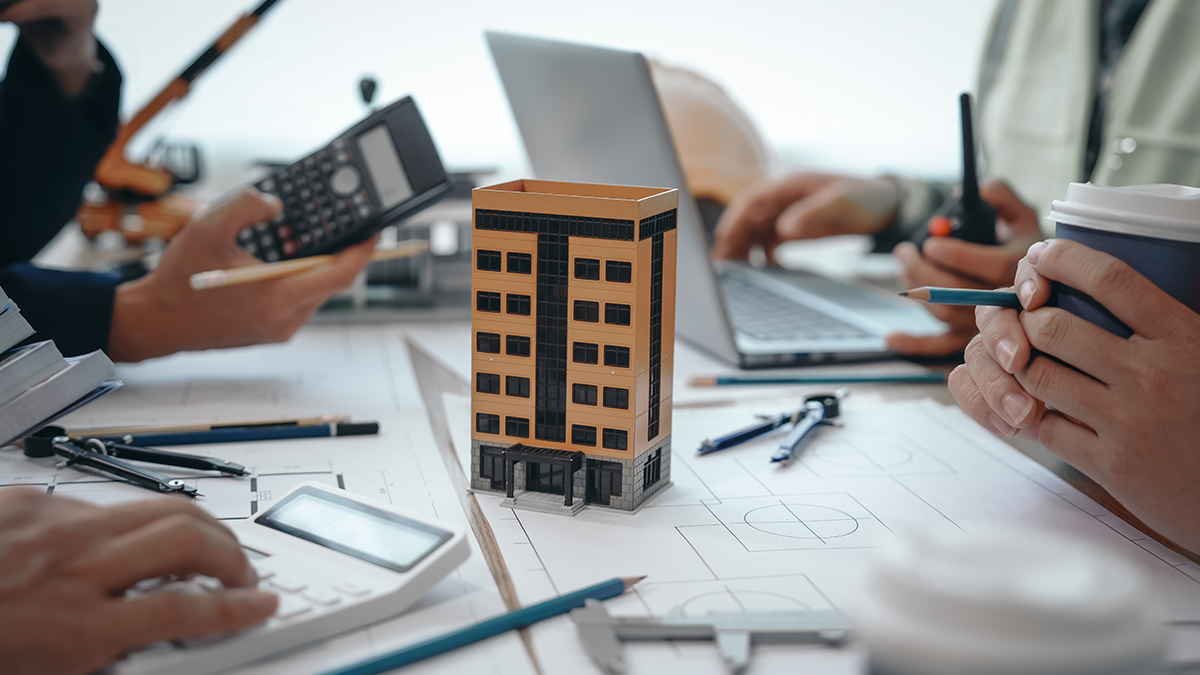 Business meeting with a small building in the middle of the table