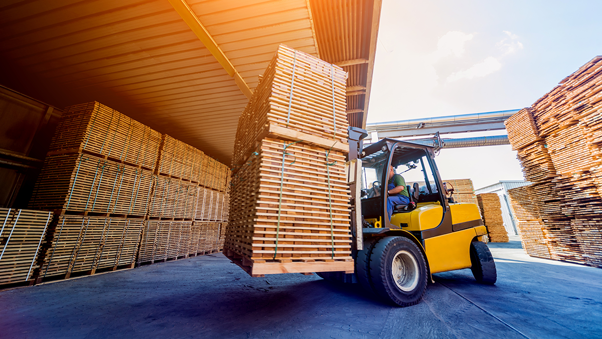 A forklift lifting timber