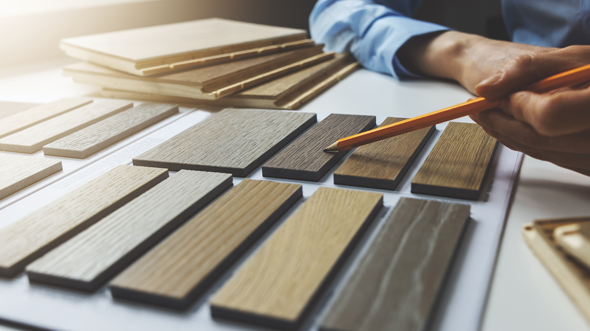 A man with a pencil pointing to different hardwoods