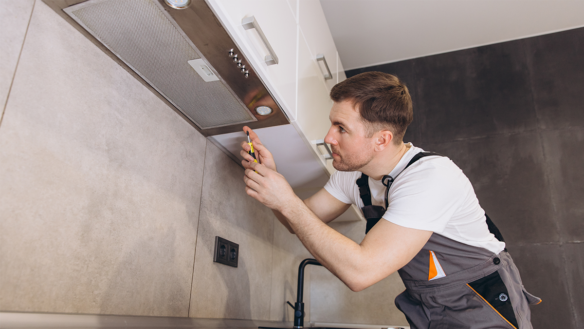 A man installing a extractor fan